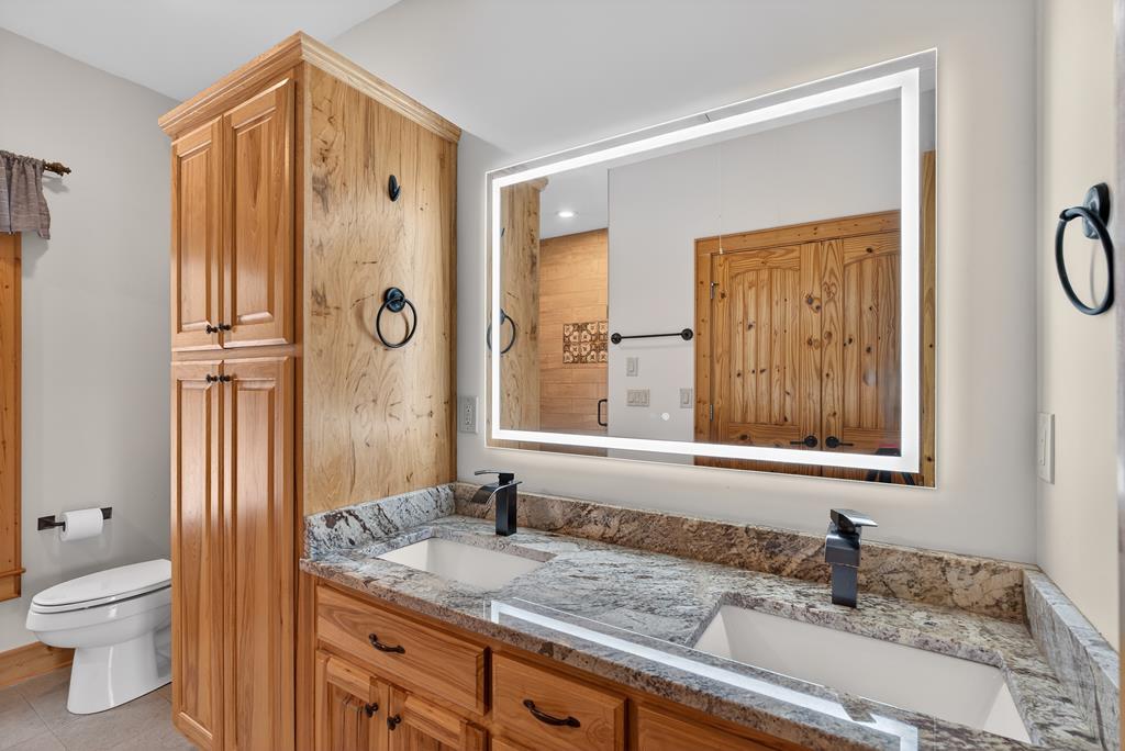 496 John Crow Road Dahlonega, GA 30533 - Photo 19 of 74 a bathroom with a granite countertop sink toilet and shower