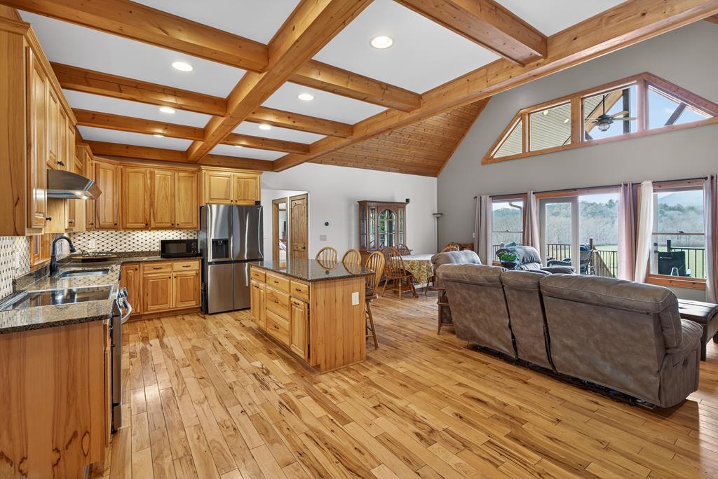 496 John Crow Road Dahlonega, GA 30533 - Photo 6 of 74 a living room with couches a kitchen with wooden floors and stainless steel appliances