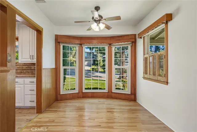 a view of an empty room with a window and a ceiling fan