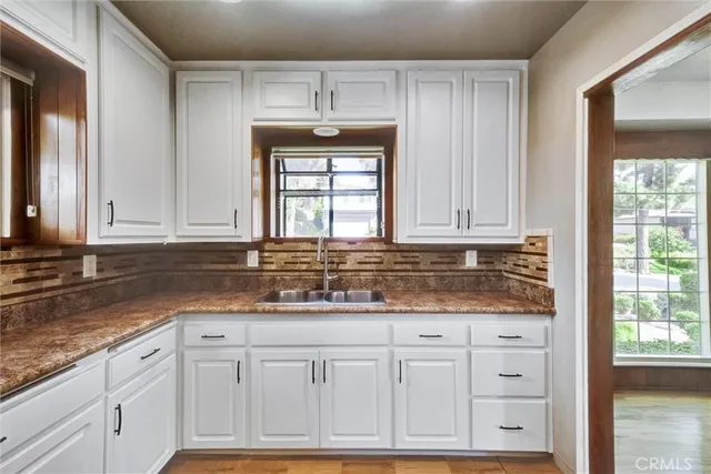a kitchen with granite countertop a sink and cabinets