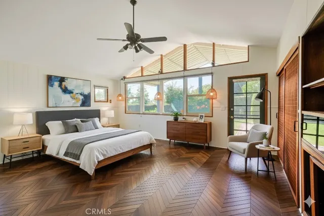 a spacious bedroom with a bed a couch and a large window