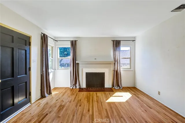 a view of a livingroom with wooden floor and a fireplace