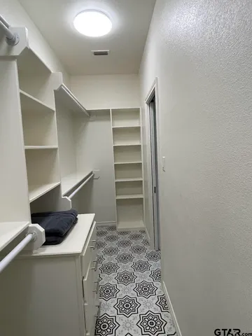 a view of walk in closet with empty racks