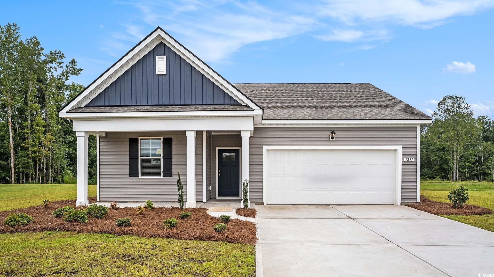 View of front of house with board and batten siding, a porch, an attached garage, and driveway