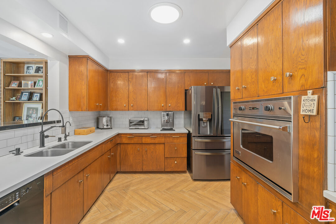 1534 Belleau Road Glendale, CA 91206 - Photo 15 of 40 a kitchen with stainless steel appliances granite countertop a refrigerator a sink dishwasher a stove with wooden cabinets and floor