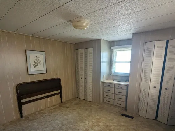 a view of a room with cabinet a ceiling fan and a bathtub