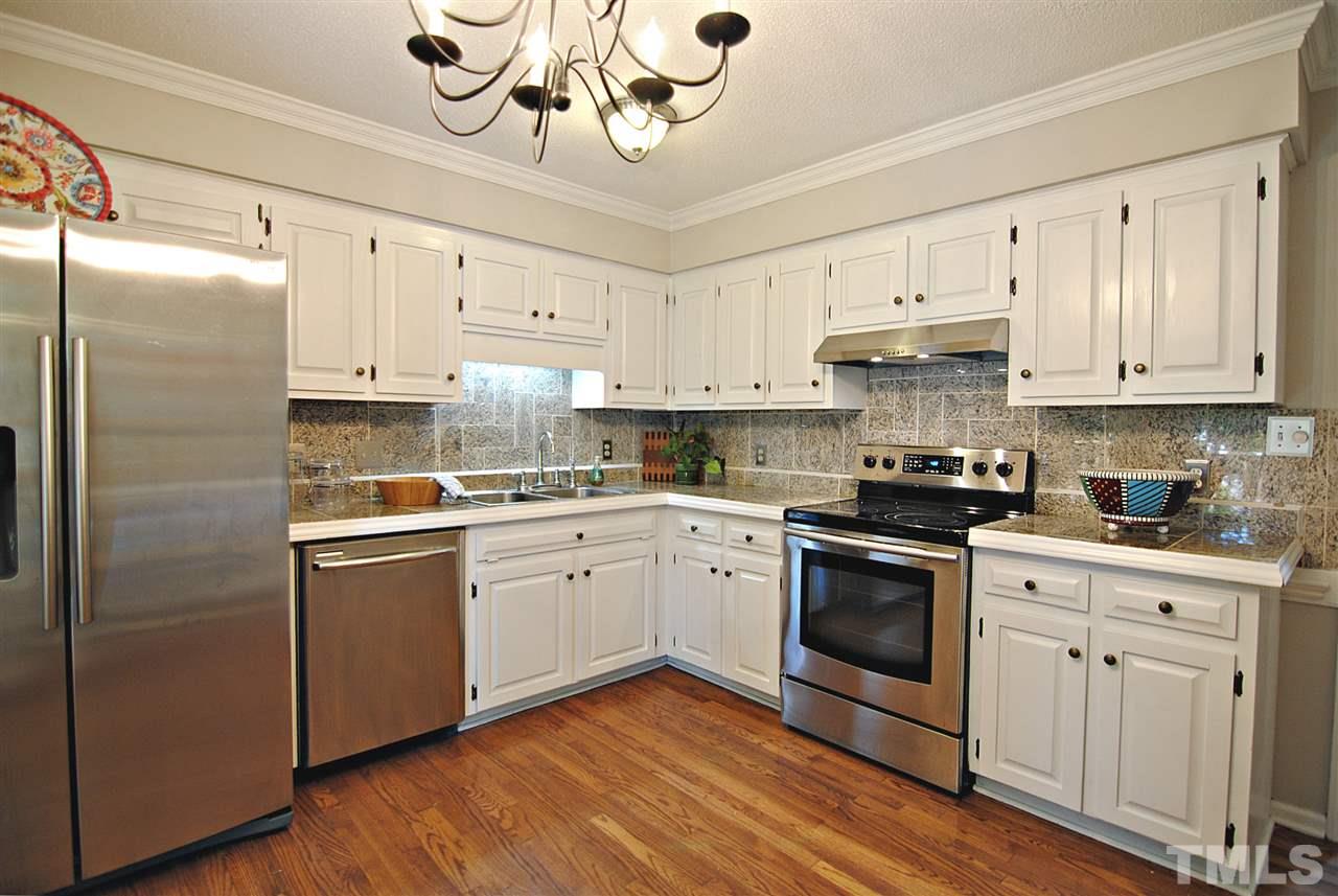 1716 Park Ridge Way Raleigh, NC 27614 - Photo 8 of 24 a kitchen with cabinets stainless steel appliances and wooden floor
