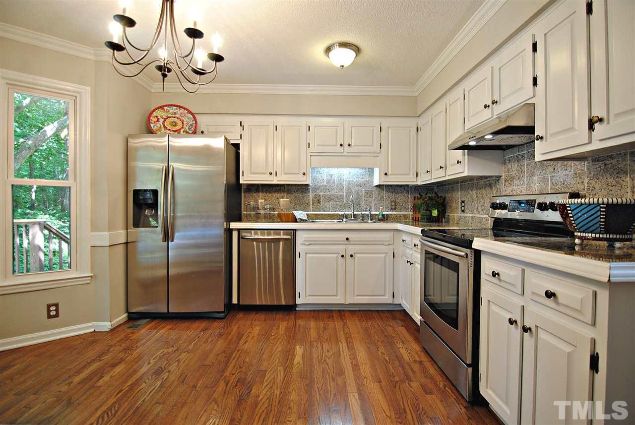 1716 Park Ridge Way Raleigh, NC 27614 - Photo 9 of 24 a kitchen with granite countertop a refrigerator a sink dishwasher a stove and white cabinets with wooden floor