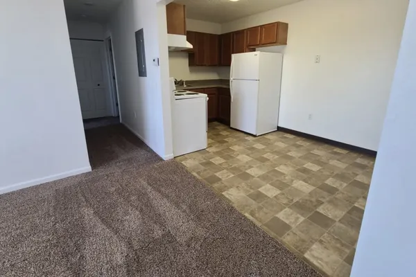 a view of a kitchen with refrigerator and a stove
