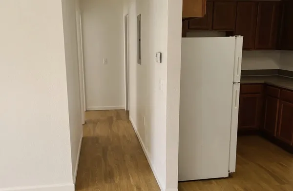 a view of a hallway with wooden floor