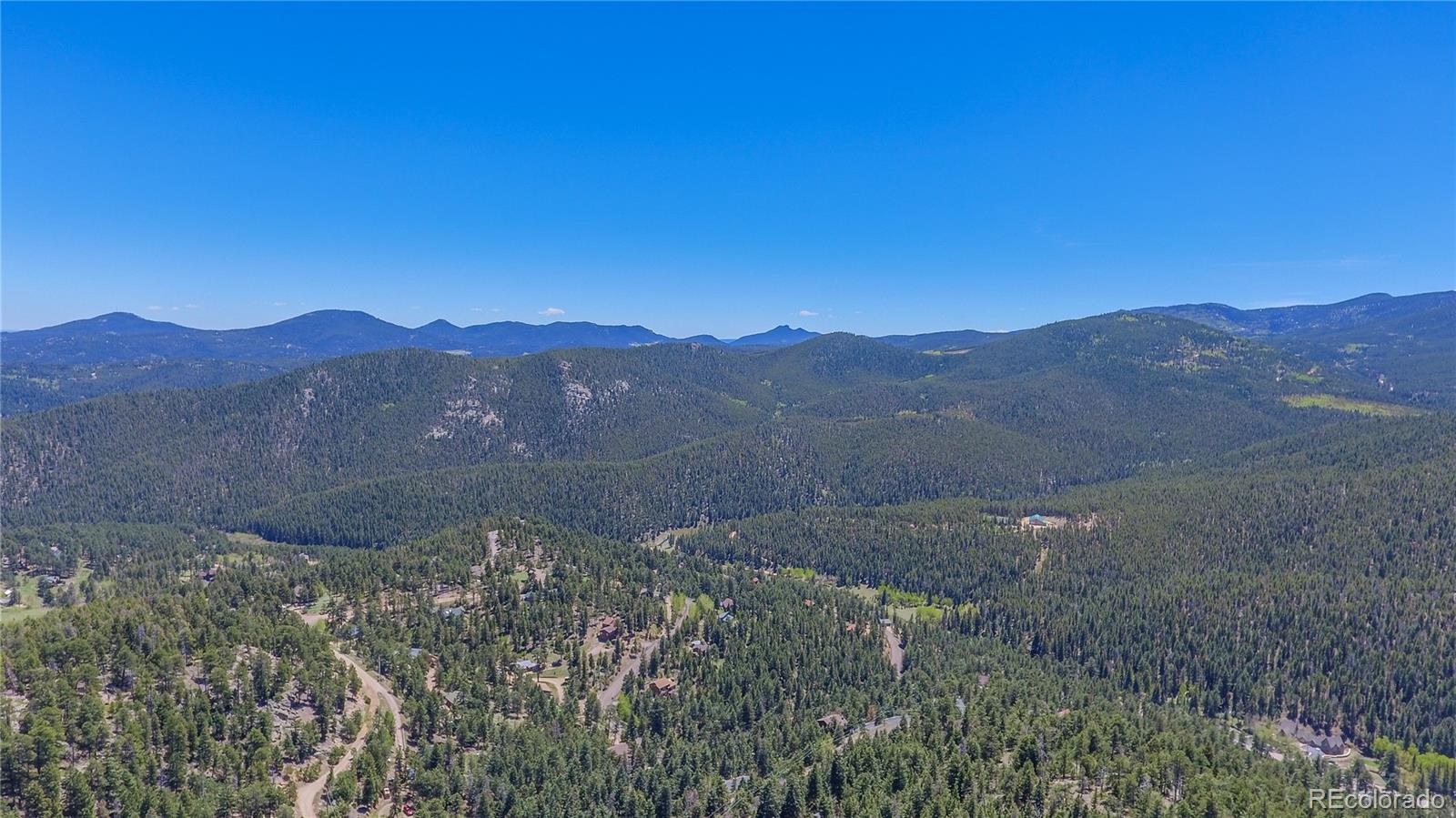 7291 Timber Trail Road Evergreen, CO 80439 - Photo 5 of 7 a view of a mountain range with a lush green hillside