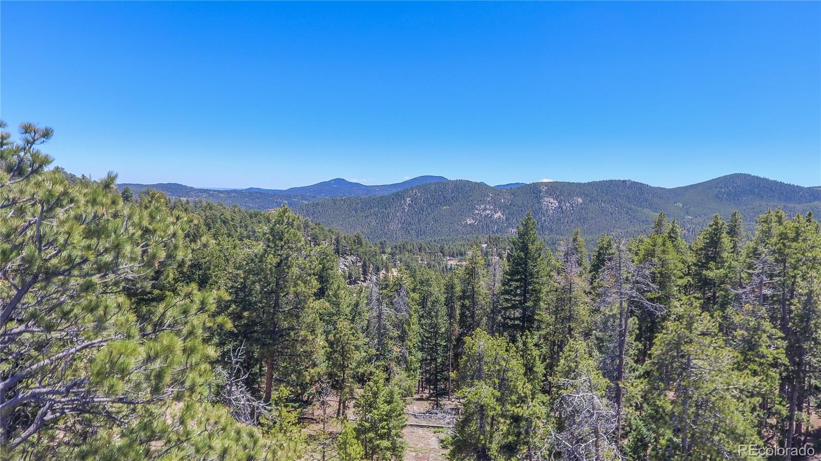 7291 Timber Trail Road Evergreen, CO 80439 - Photo 6 of 7 a view of a town with mountains in the background