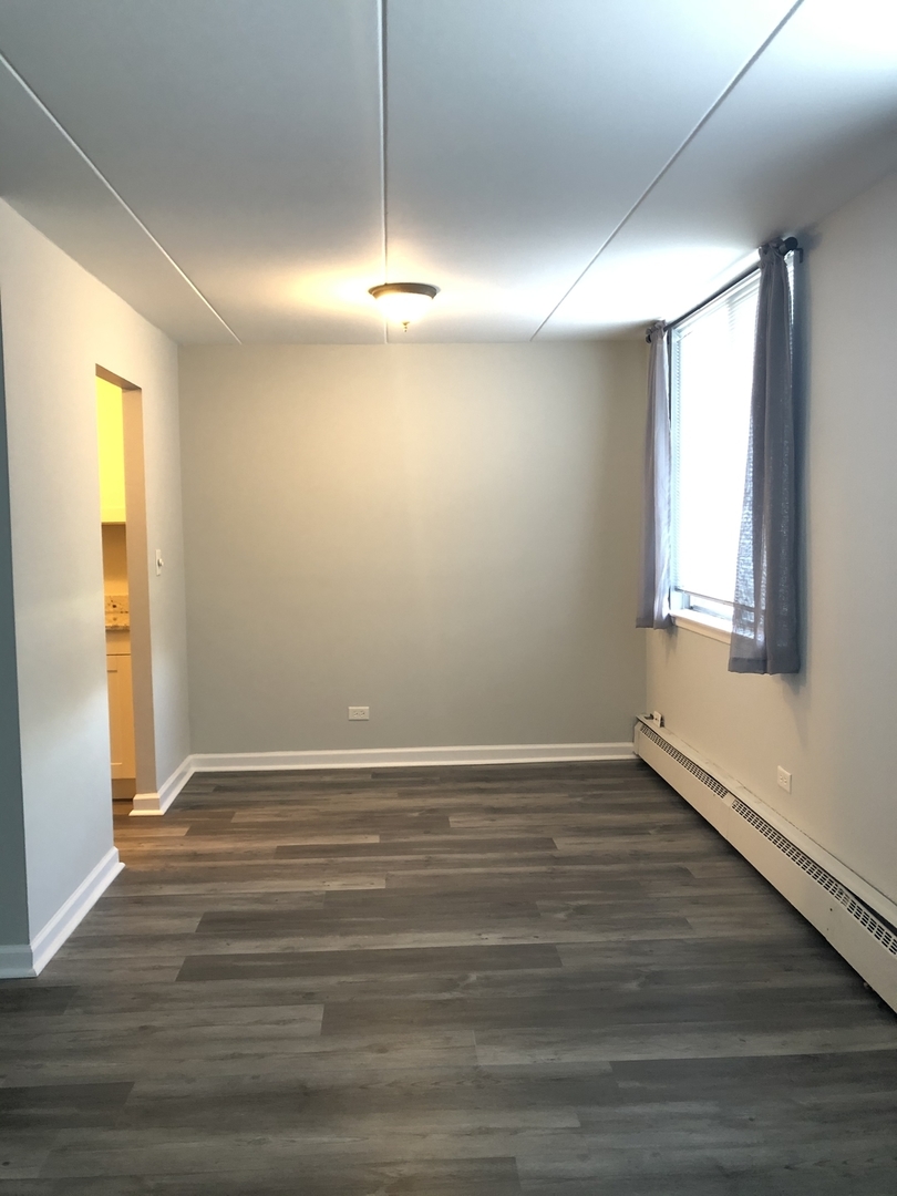 225 South Rohlwing Road, Unit 106 Palatine, IL 60074 - Photo 6 of 17 an empty room with wooden floor and windows