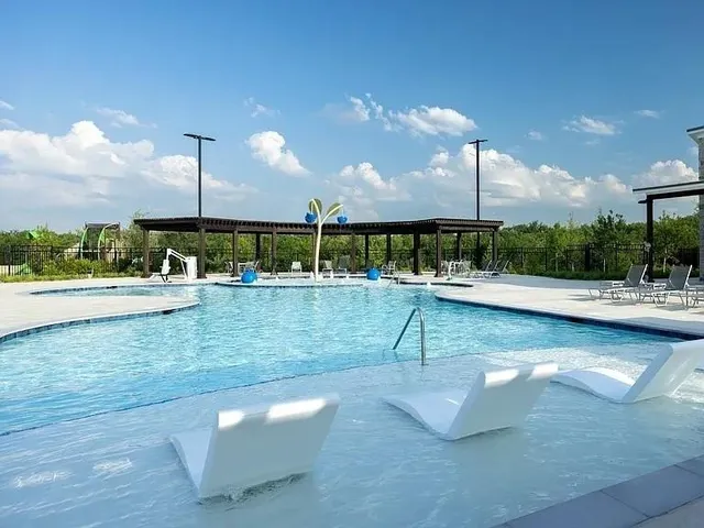 a view of a swimming pool with a patio and a fountain