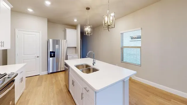 a kitchen that has a lot of cabinets and wooden floor