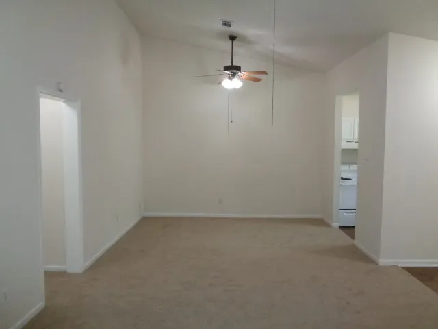 an empty room with chandelier fan