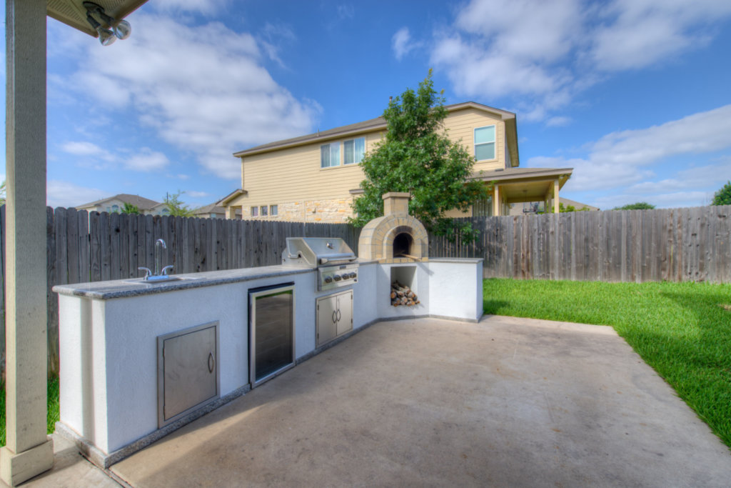 11204 Old Quarry Road Austin, TX 78717 - Photo 17 of 18 An outdoor kitchen with built-in barbecue and pizza oven sits on a concrete patio.