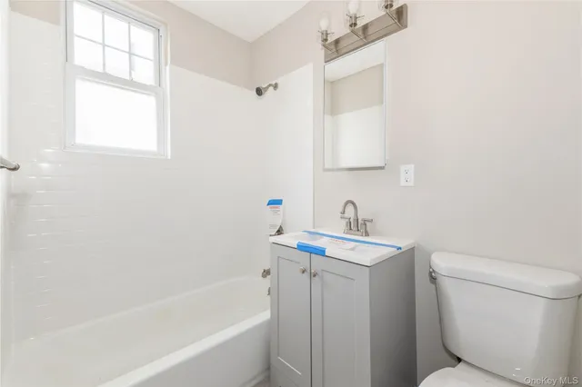 a bathroom with a sink toilet vanity and bathtub