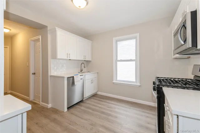 a kitchen with a stove a sink and a window