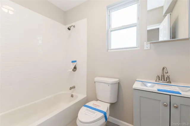 a bathroom with a toilet a sink a mirror and a bathtub