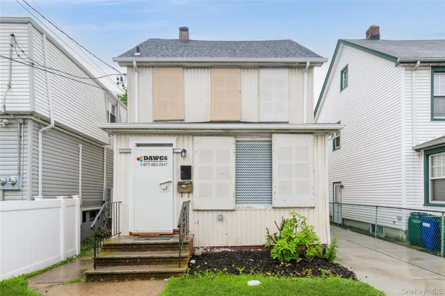 a view of a house with a small yard and potted plants