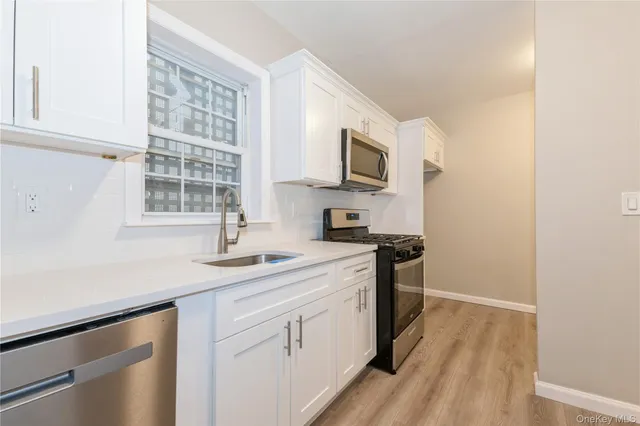 a kitchen with stainless steel appliances granite countertop a sink and a stove top oven