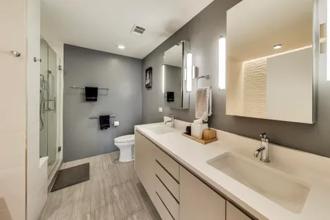 a bathroom with a sink a toilet and shower