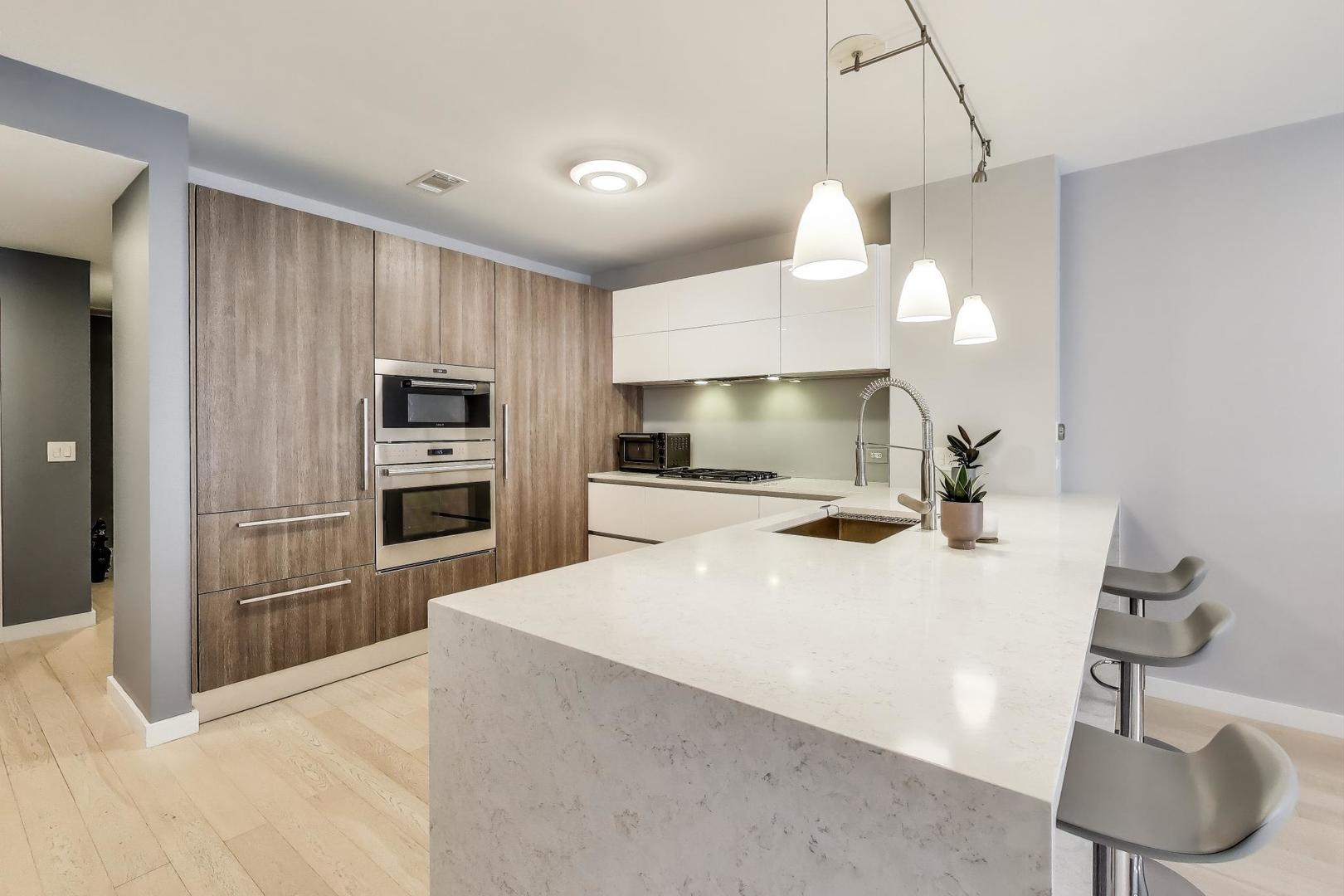 520 North Halsted Street, Unit 410 Chicago, IL 60642 - Photo 3 of 31 a large kitchen with kitchen island a sink stainless steel appliances and cabinets