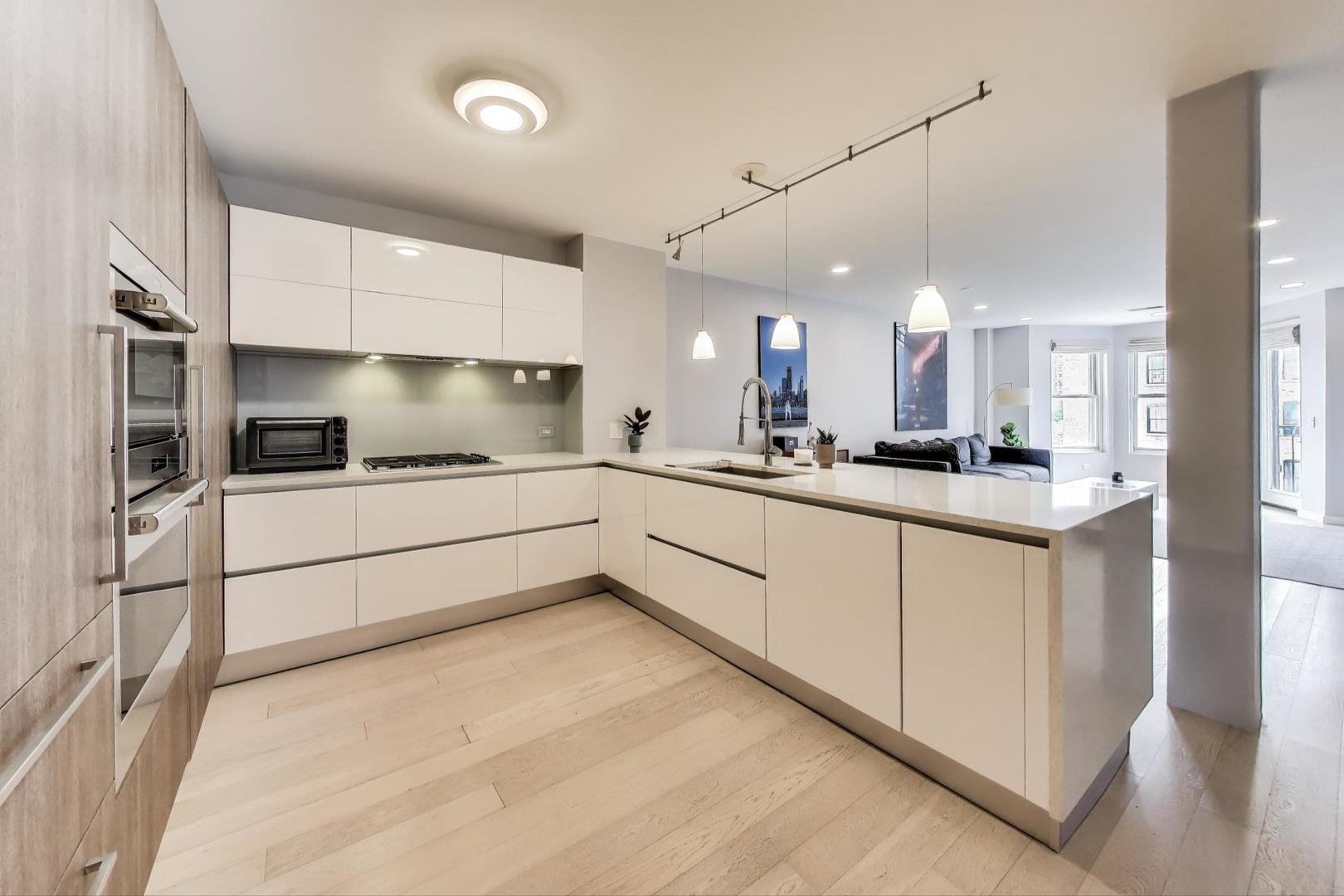 520 North Halsted Street, Unit 410 Chicago, IL 60642 - Photo 4 of 31 a kitchen with stainless steel appliances kitchen island granite countertop a refrigerator and a sink