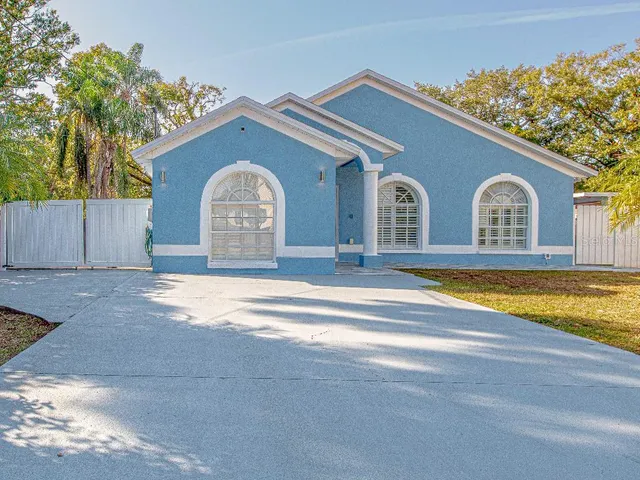 a view of a house with a yard and a large tree