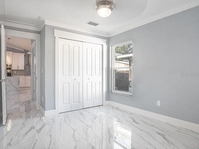 an empty room with windows and closet