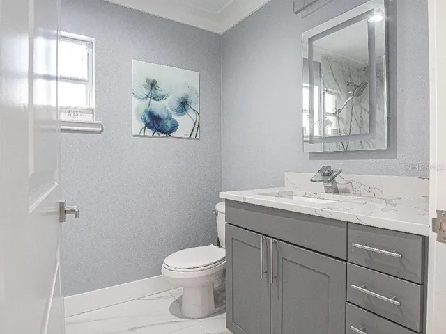 a bathroom with a toilet sink and mirror