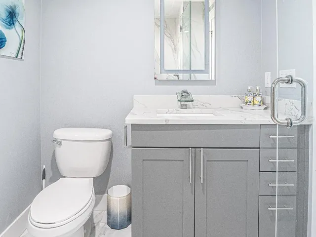 a bathroom with a toilet sink and mirror