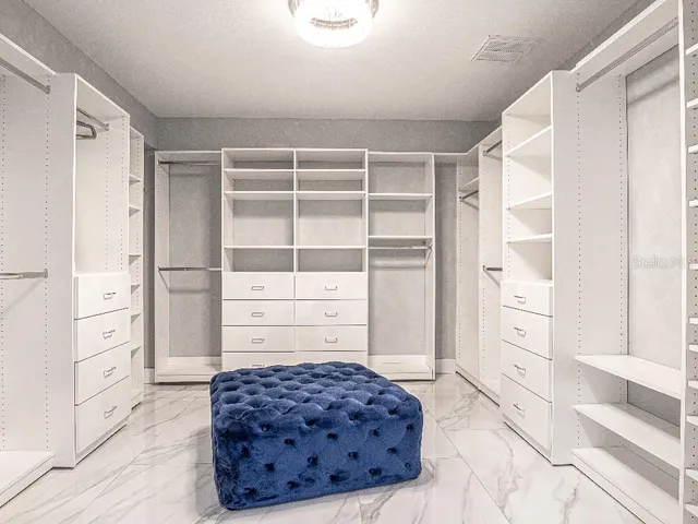 a living room with cabinets and chair