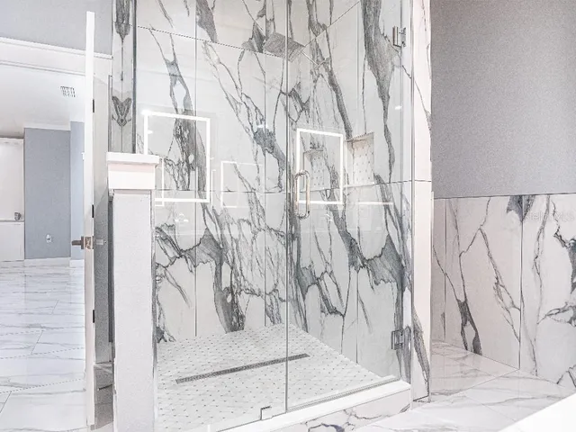 a white bath tub sitting next to a white wall