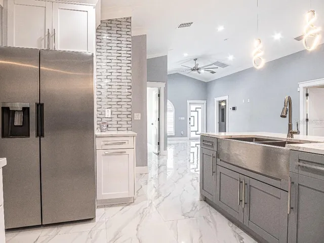 a kitchen with kitchen island a counter top space cabinets and stainless steel appliances