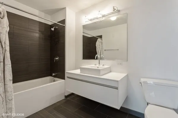a bathroom with a sink a toilet a mirror and bathtub
