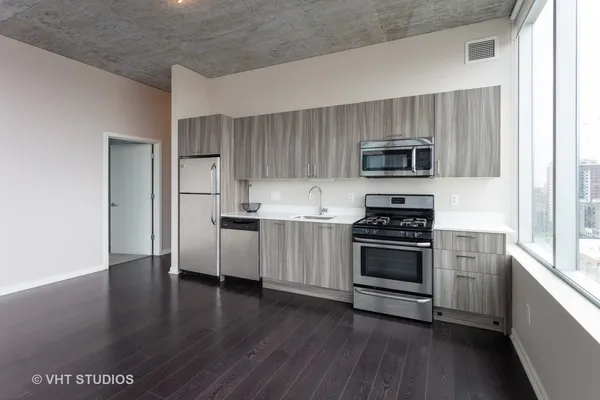 a kitchen with granite countertop white cabinets and stainless steel appliances