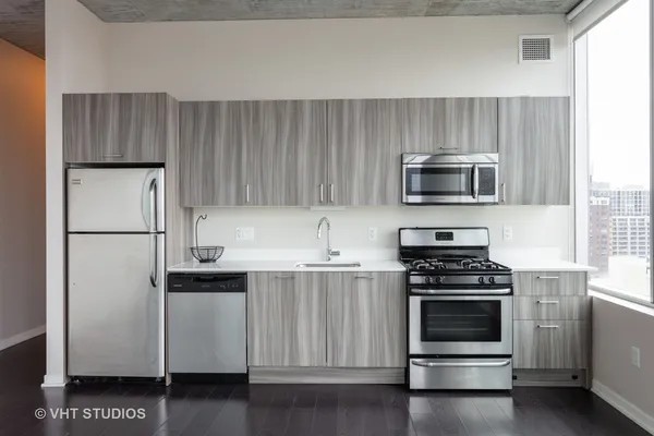 a kitchen with cabinets stainless steel appliances and wooden floor
