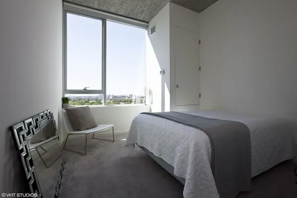 a bed sitting in a bedroom next to a window