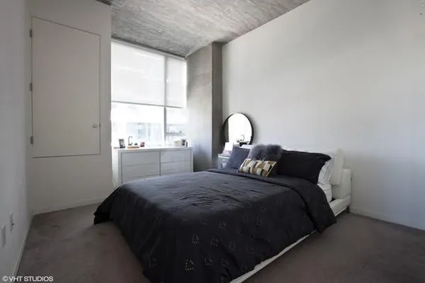 a bed sitting in a bedroom next to a window