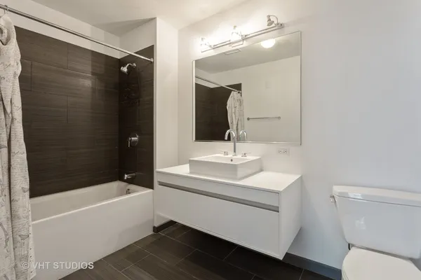 a bathroom with a sink a toilet a mirror and bathtub