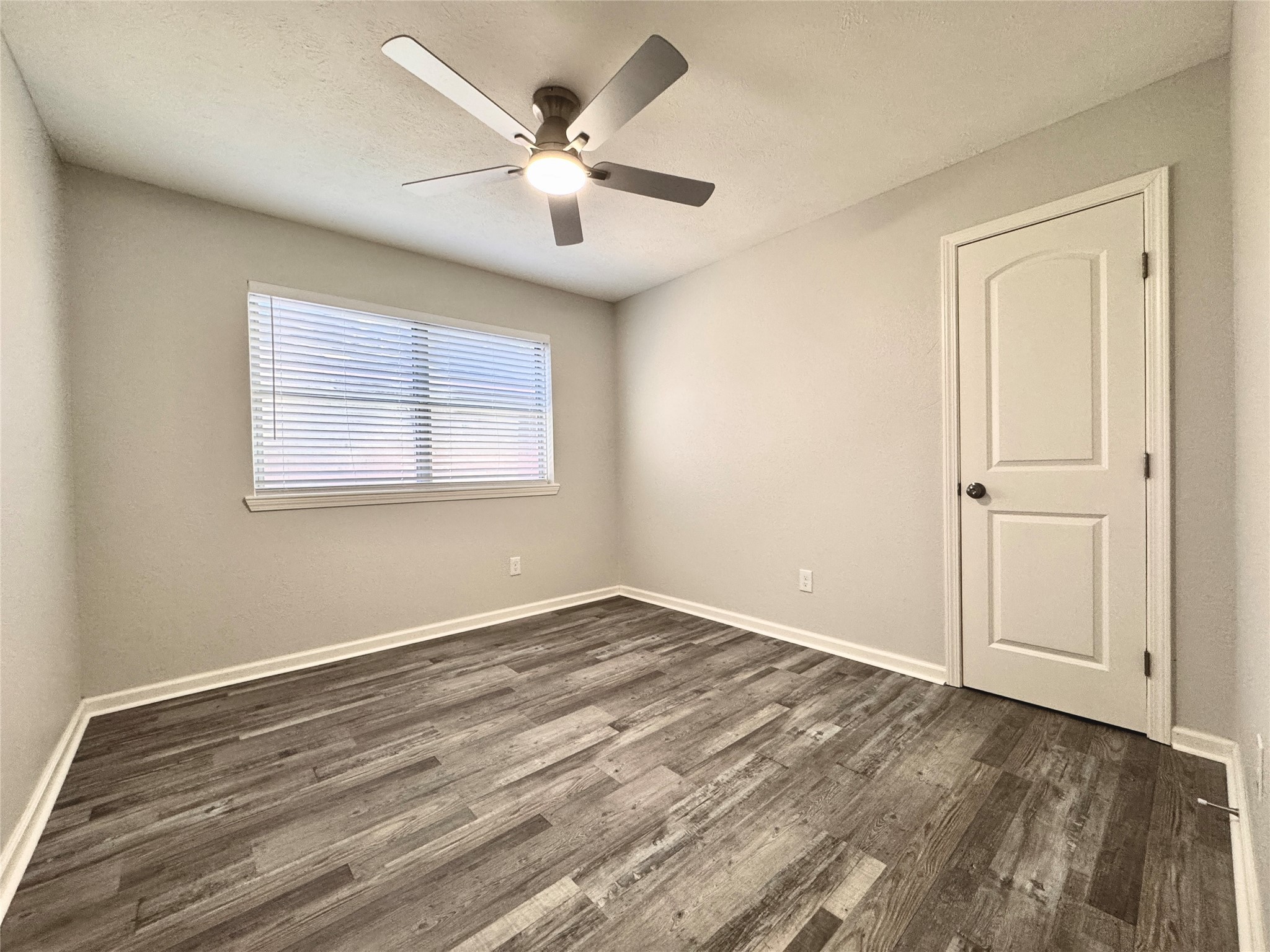 5115 Hialeah Drive Houston, TX 77092 - Photo 16 of 21 an empty room with wooden floor chandelier fan and windows