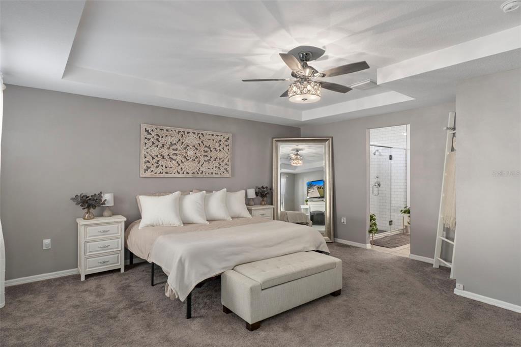 3313 Dorian Avenue Spring Hill, FL 34606 - Photo 23 of 57 a spacious bedroom with a bed and a chandelier