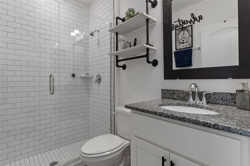 3313 Dorian Avenue Spring Hill, FL 34606 - Photo 38 of 57 a bathroom with a granite countertop toilet sink and mirror