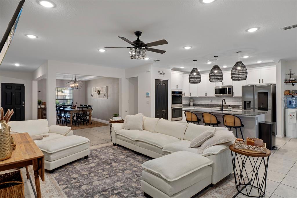 3313 Dorian Avenue Spring Hill, FL 34606 - Photo 5 of 57 a living room with furniture kitchen view and a chandelier