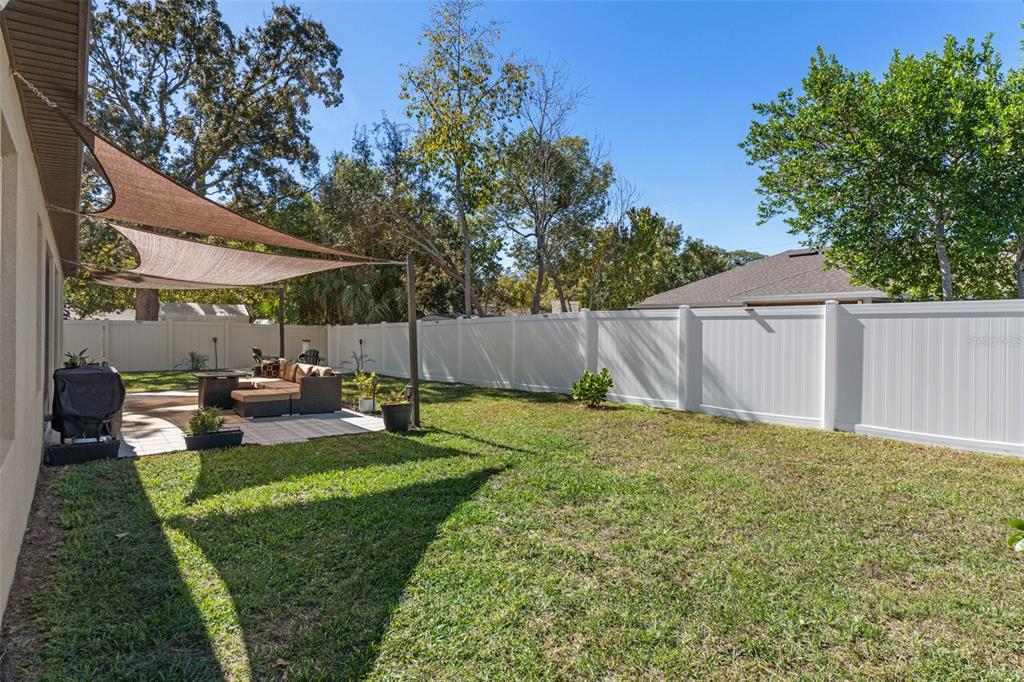3313 Dorian Avenue Spring Hill, FL 34606 - Photo 55 of 57 a view of a backyard with table and chairs potted plants and a large tree