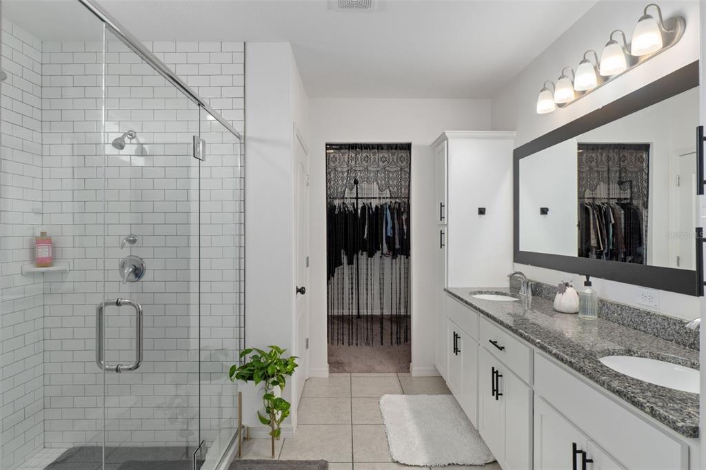 3313 Dorian Avenue Spring Hill, FL 34606 - Photo 6 of 57 a spacious bathroom with a granite countertop sink a mirror and a shower