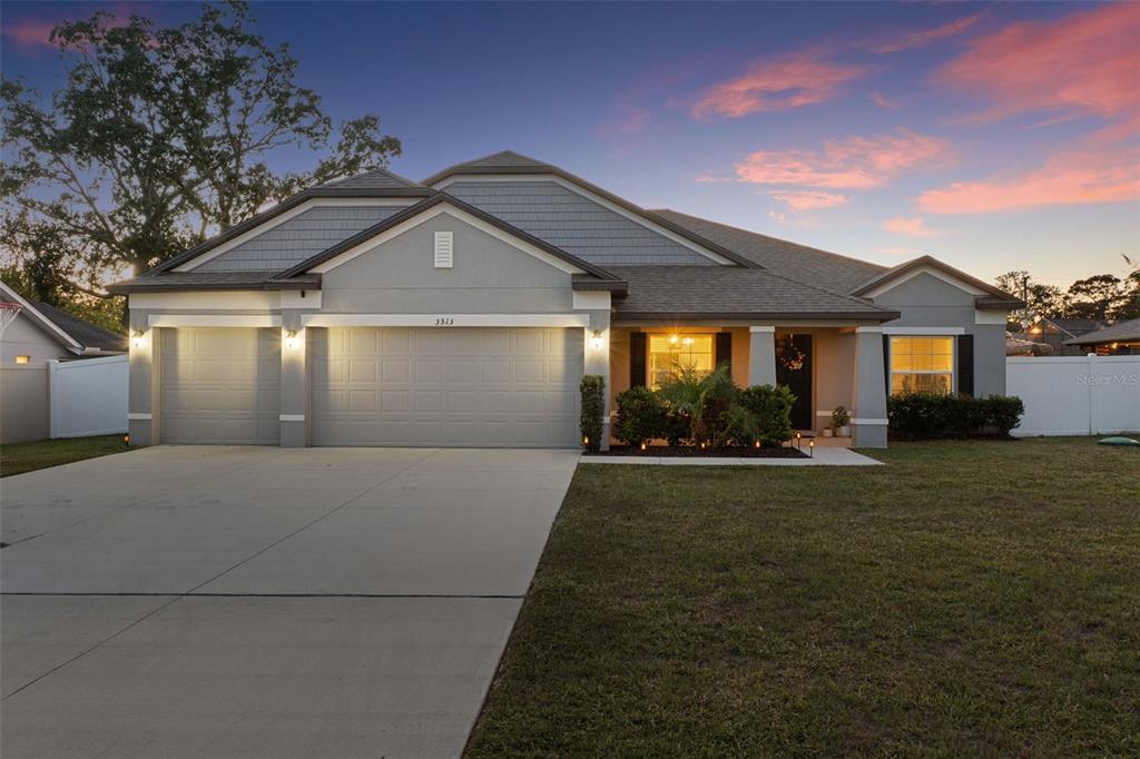 3313 Dorian Avenue Spring Hill, FL 34606 - Photo 7 of 57 a front view of a house with a garden and yard