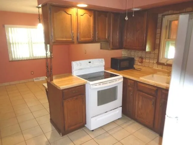 a kitchen that has a sink and a stove in it